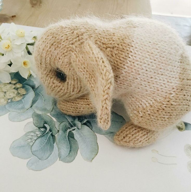 a stuffed animal sitting on top of a table next to flowers