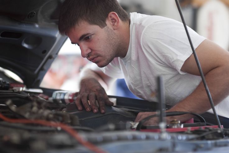 a man working on an engine in a garage