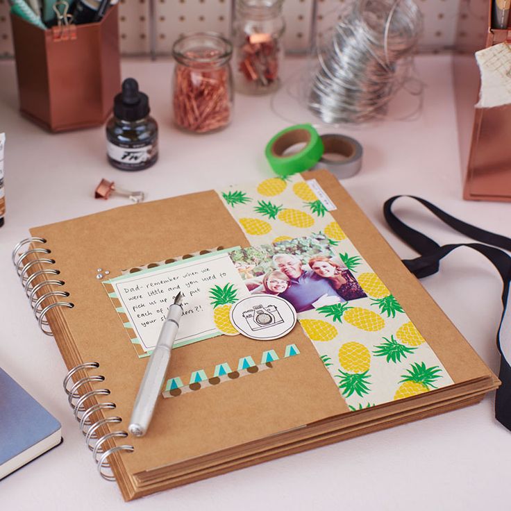 an open notebook sitting on top of a table next to scissors and other office supplies