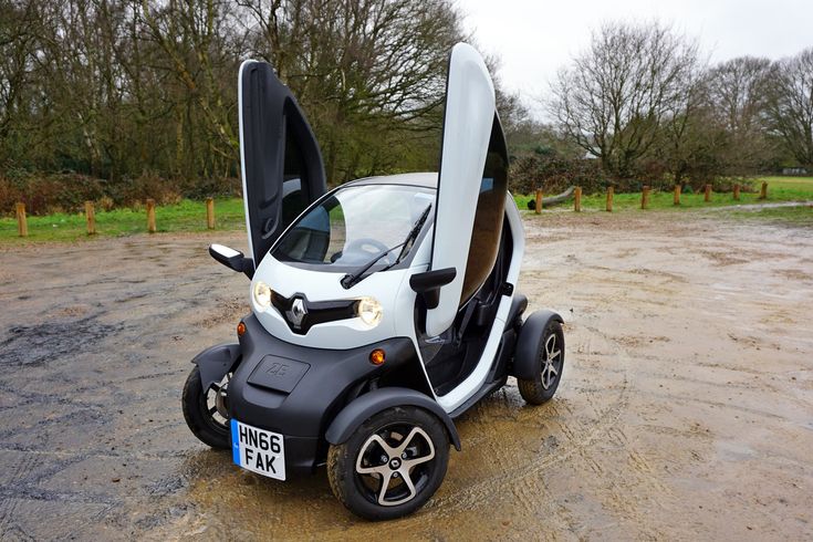 an electric car with its doors open in the mud