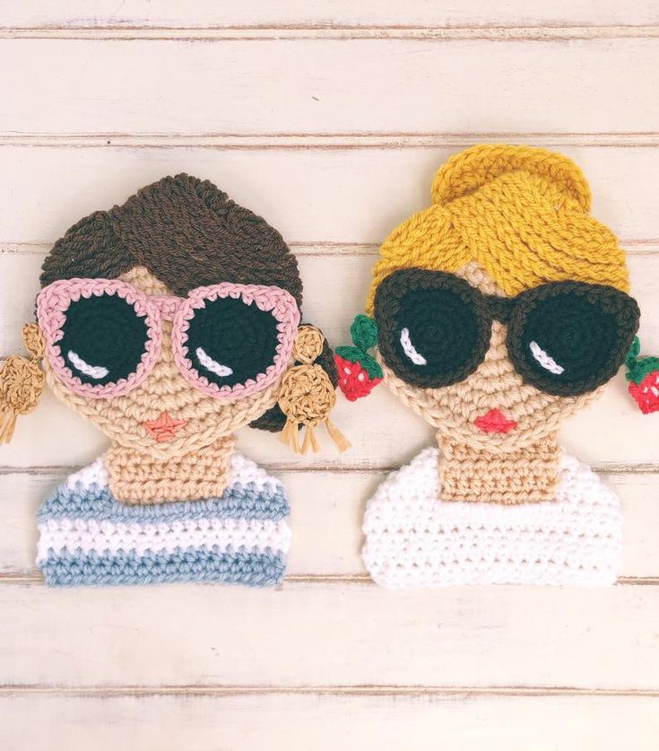 two crocheted dolls wearing sunglasses on top of each other