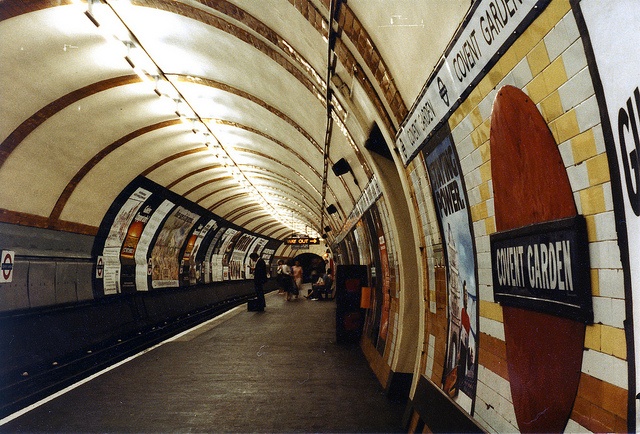 an underground subway station with people walking on the platform