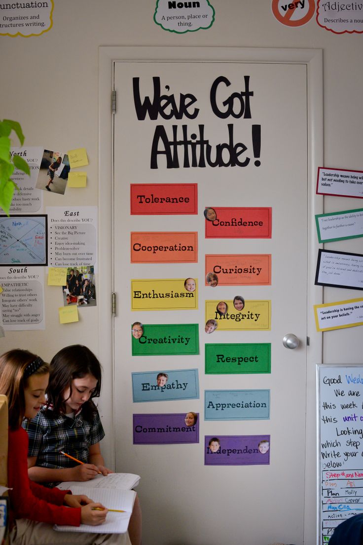 two children sitting in front of a bulletin board