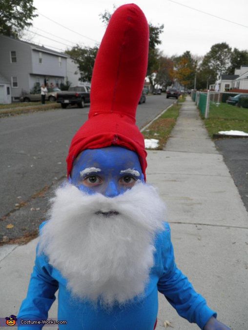 a man in blue and red is standing on the sidewalk