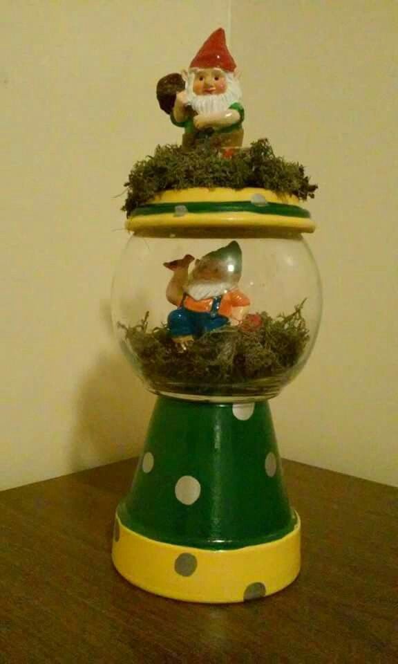 two snow globes are stacked on top of each other with gnome figurines in them