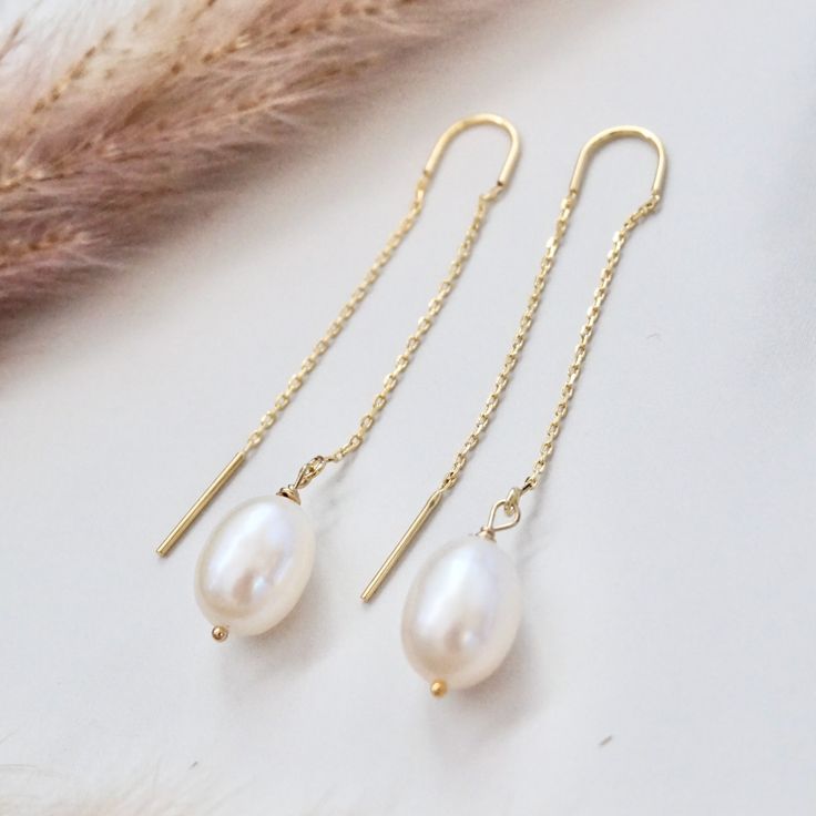 These dainty pearl drop earrings feature lustrous genuine freshwater pearl gemstones, suspended on a delicate chain creating a thread through earrings that is unique and eye catching. Threader earrings are lightweight earrings, which consist of a delicate chain that threads through the earlobe, showcasing the stunning pearls suspended in mid -air for a mesmerizing effect. These pearl earrings are perfect to pair with your summer dresses or wedding guest dresses. Details:---------- - lustrous gen Cheap Pearl Beaded Earrings For Party, Drop Down Pearl Earrings, Minimalist Pearl Drop Earrings, Delicate Threader Earrings With Delicate Chain For Gift, Everyday Long Drop Earrings With Pearl Charm, Delicate Threader Earrings With Chain For Gift, Delicate Pearl Chain Earrings For Everyday, 14k Gold Filled Drop Pearl Earrings With Pearl Pendant, 14k Gold Filled Dangle Earrings With Pearl Pendant