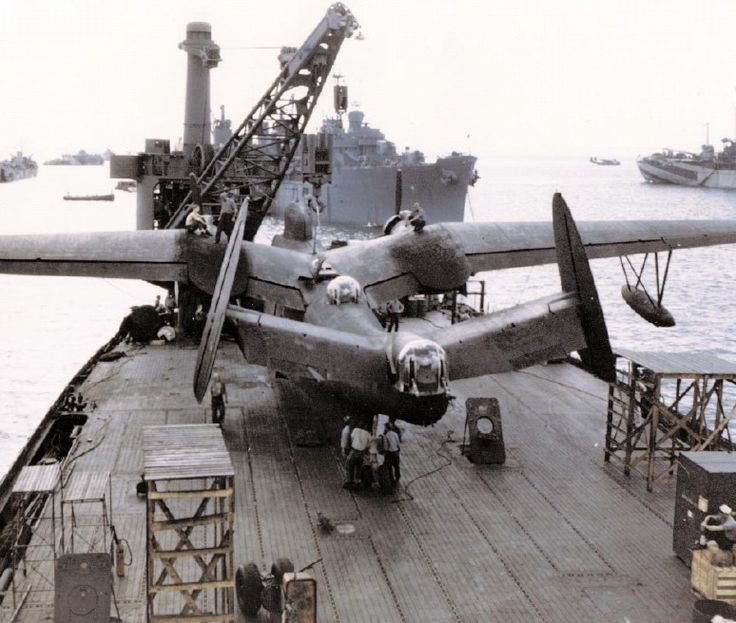 an old airplane is parked on the deck of a ship