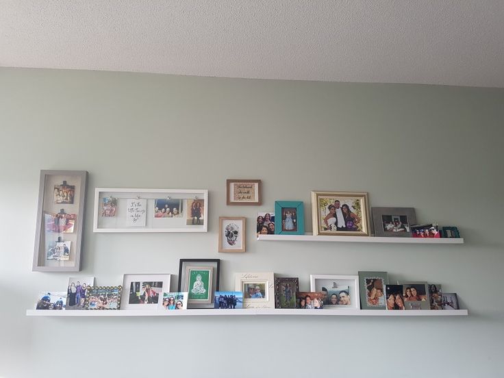 the shelves are filled with photos and pictures on them, all lined up against the wall