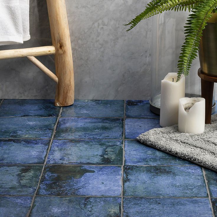 a bathroom with blue tile floors and white towels