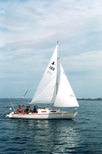 a sailboat with three people on it in the water