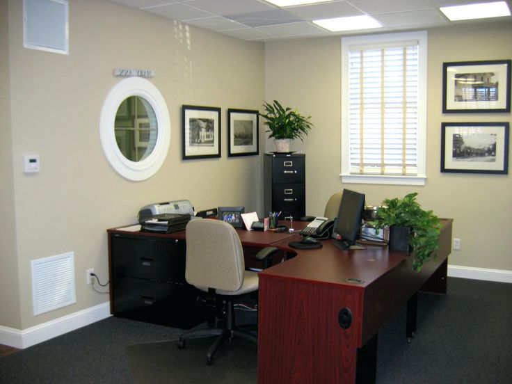 an office with a desk, chair and pictures on the wall