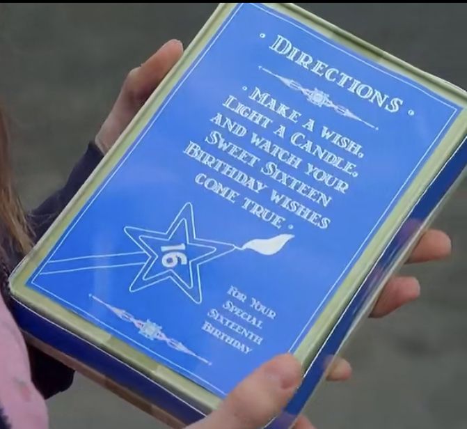 a person holding up a blue plaque that says directions make a wish, i have a nine - pointed star between them