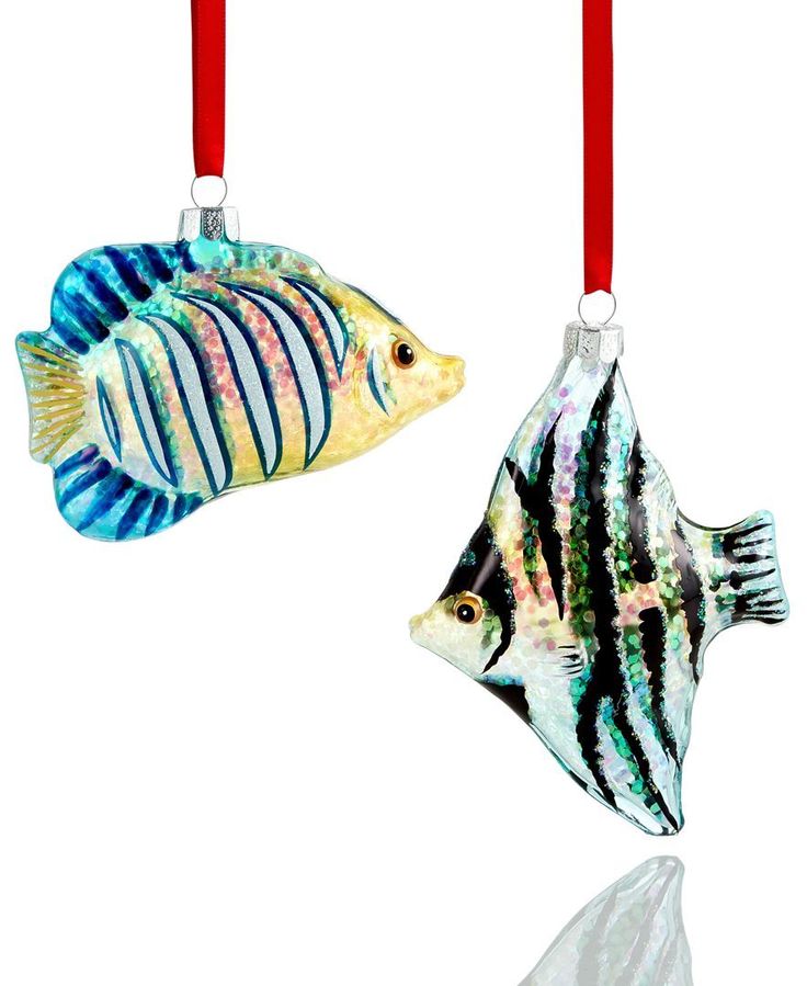 two colorful glass ornaments hanging from red string on a white background with reflection in the water