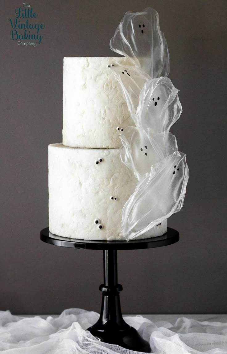 a three layer cake with ghost decorations on it