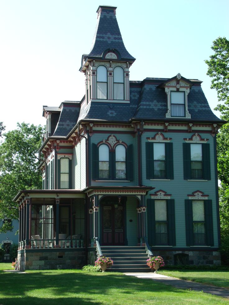 a large blue house sitting on top of a lush green field