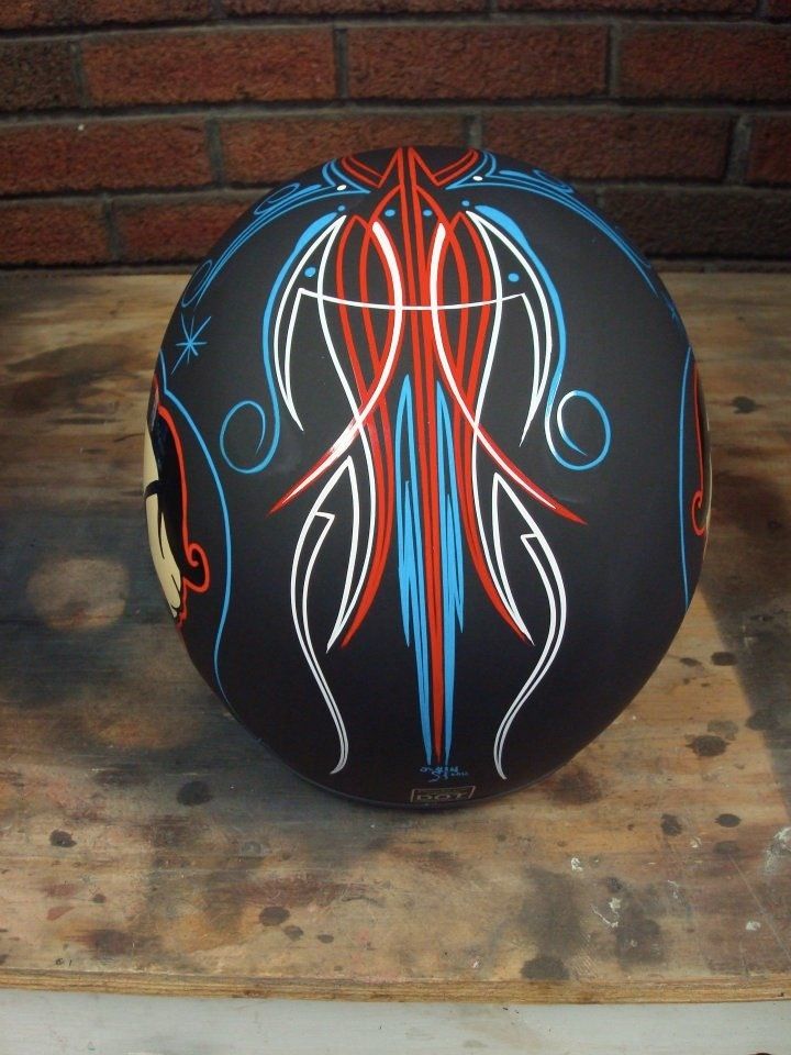 a painted motorcycle helmet sitting on top of a wooden table