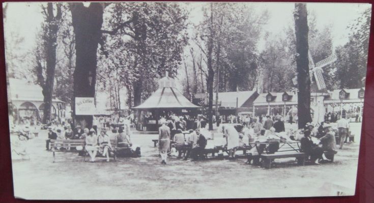 an old black and white photo of people in front of a tent at a fair