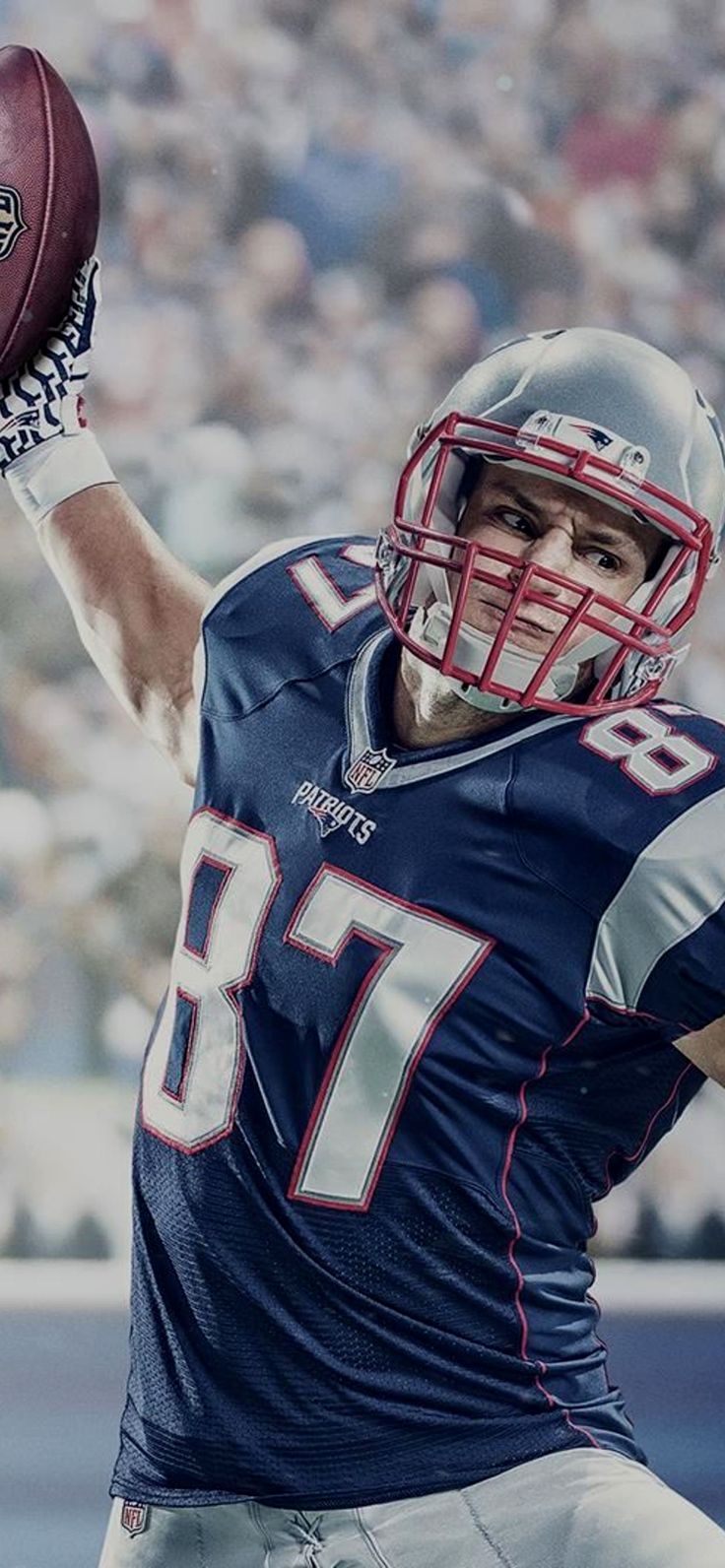 a man holding a football in his right hand and wearing a uniform with numbers on it