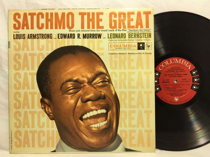 a record with an image of the smiling man on it's side, next to a vinyl album cover