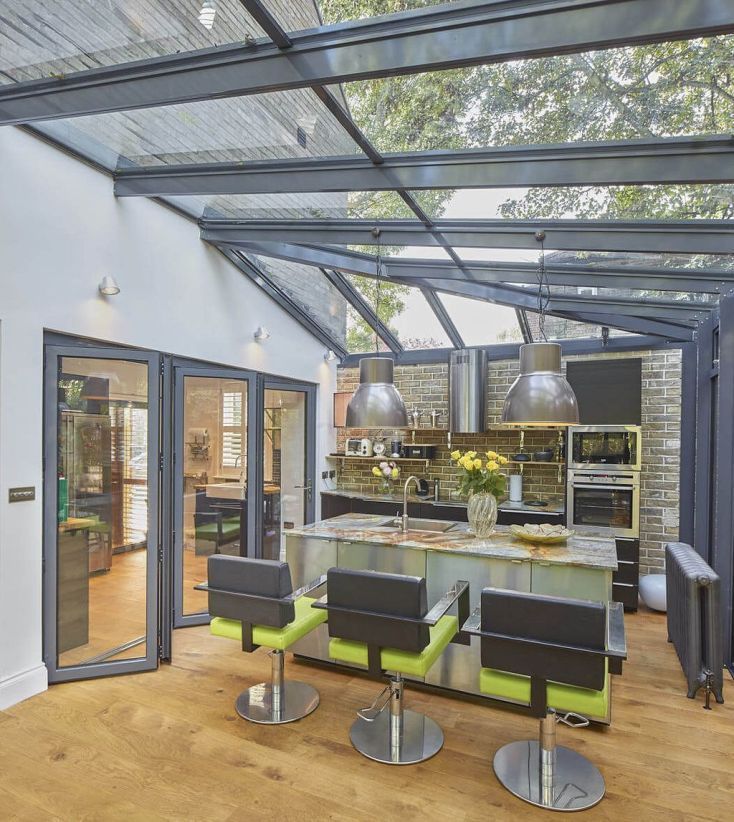 an open kitchen and dining area with wooden floors