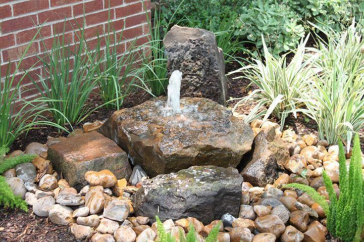 there is a rock fountain in the garden