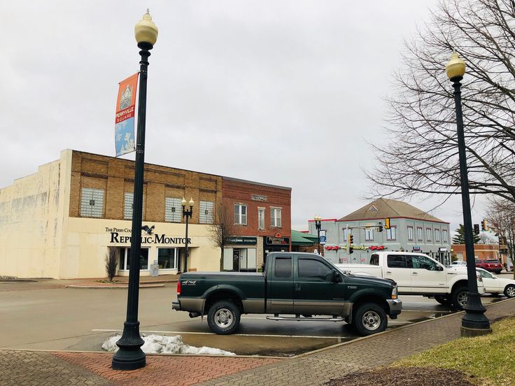 the truck is parked on the side of the road in front of the storefront