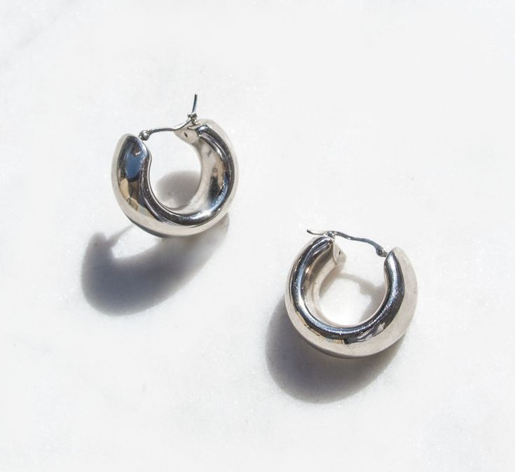 Elevate your minimalist style with our 925 silver donut hoop earrings, an iconic piece from our vintage silver jewelry collection. Crafted in the silver capital of Taxco, Mexico, during the 1980s, these perfect vintage earrings were curated from a Dallas, Texas estate sale over a decade ago. The exquisite craftsmanship and beautiful detailing resonate through their hollow and lightweight design, adorned with a silver push backing for pierced ears. Preserving their perfect vintage condition, these earrings are ready to make a timeless statement. Shipped within 1-2 business days, these treasures arrive in our signature pink packaging, inviting you to embrace the allure of minimalist elegance. Key Details  Earring Size: 28mm x 28mm or .75 x .75 inch, 10mm thick Material: 925 Silver Condition: Timeless Silver Tarnish Resistant Hoop Earrings, Timeless Silver Drop Hoop Earrings, Minimalist Polished Sterling Silver Huggie Earrings, Silver Timeless Hoop Earrings, Everyday Rounded Earrings With Polished Finish, Everyday Polished Rounded Earrings, Everyday Rounded Polished Earrings, Minimalist Polished Hoop Earrings For Everyday, Minimalist Polished Hoop Earrings