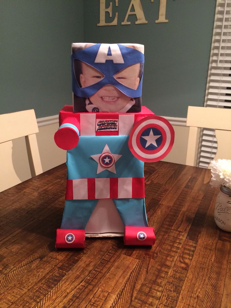 a paper cut out of captain america sitting on top of a wooden table