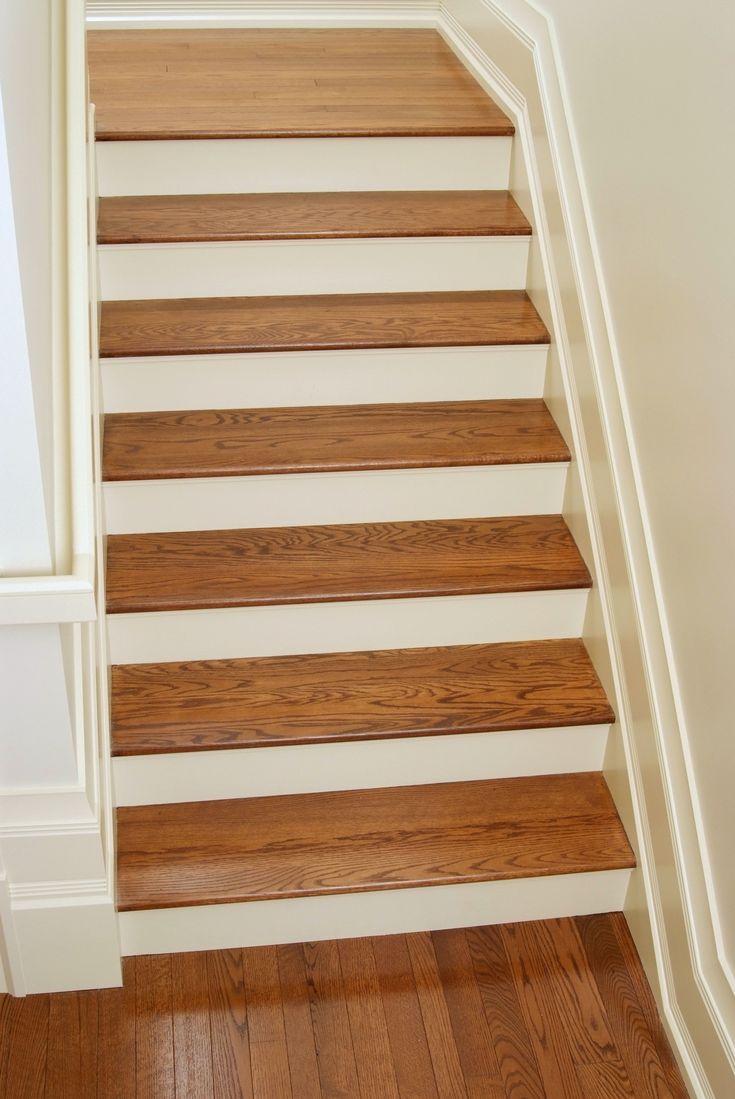 a wooden staircase with white walls and wood flooring