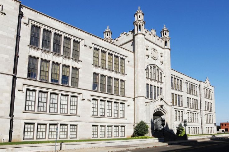 an old white building with many windows on the front and side of it's sides