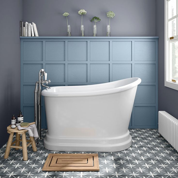 a white bath tub sitting in a bathroom next to a radiator and window