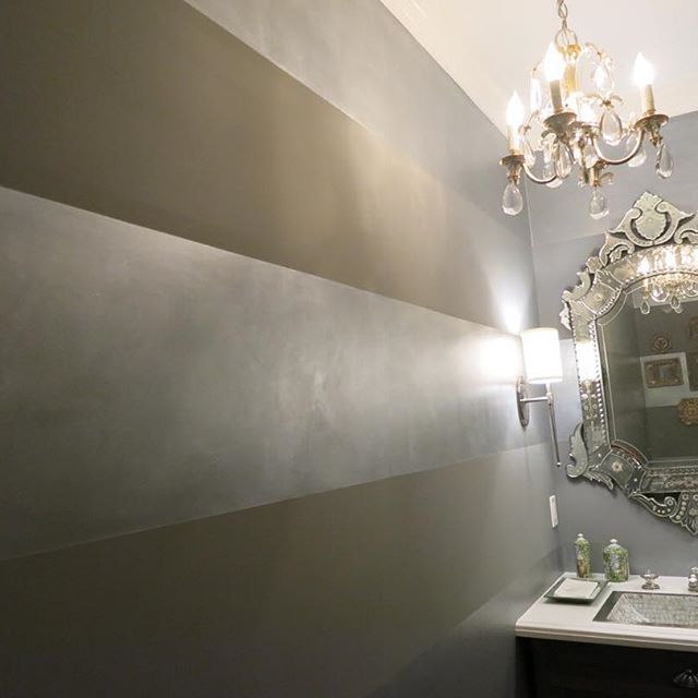 a bathroom with a sink, mirror and chandelier