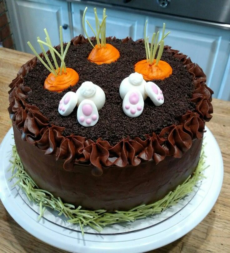 a chocolate cake decorated with carrots and bunny ears