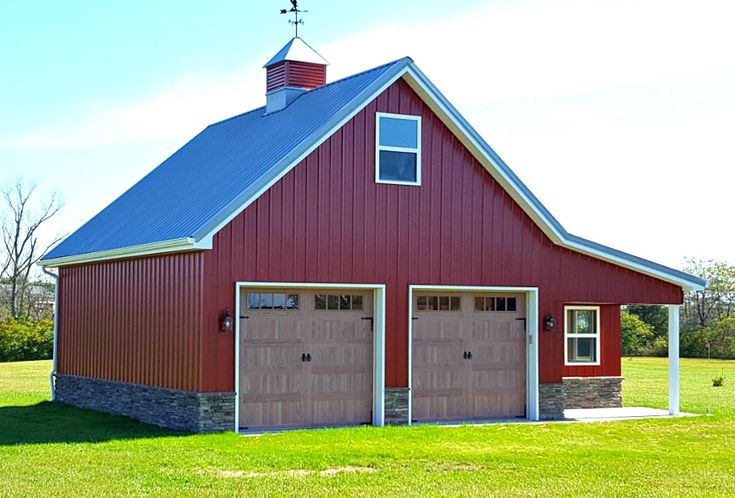 a red barn with two garages and a steeple