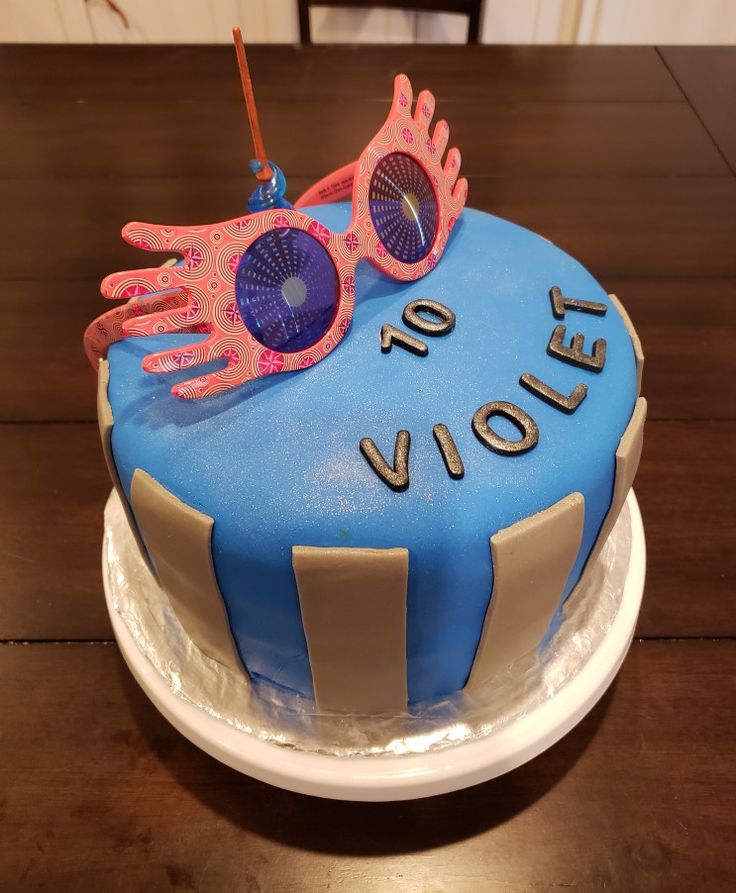 a blue cake with pink glasses on top and the words volly written on it