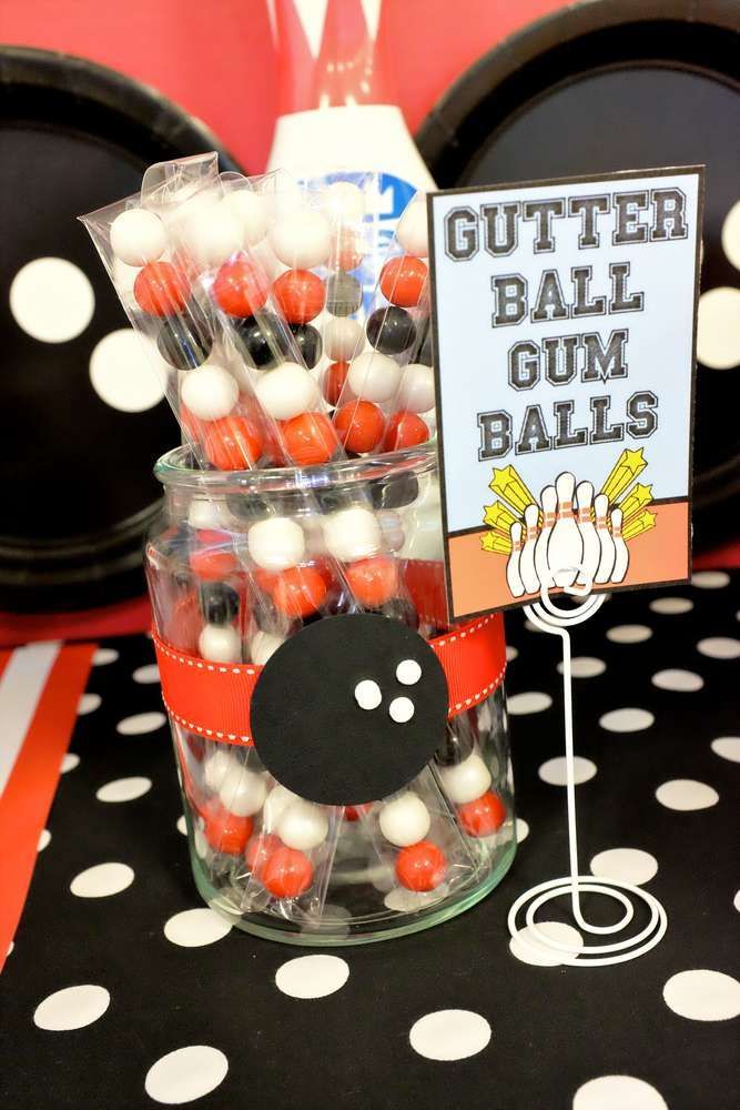 there is a glass jar with candy in it and a sign that says gutter ball gum balls