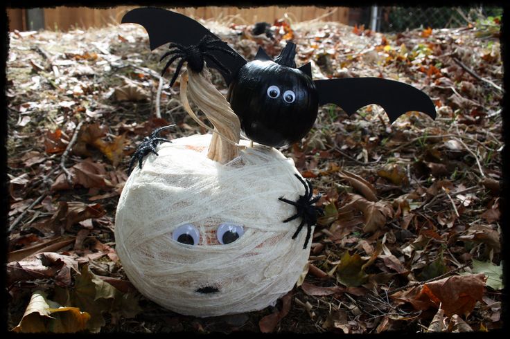 a halloween pumpkin decorated with yarn and fake bats