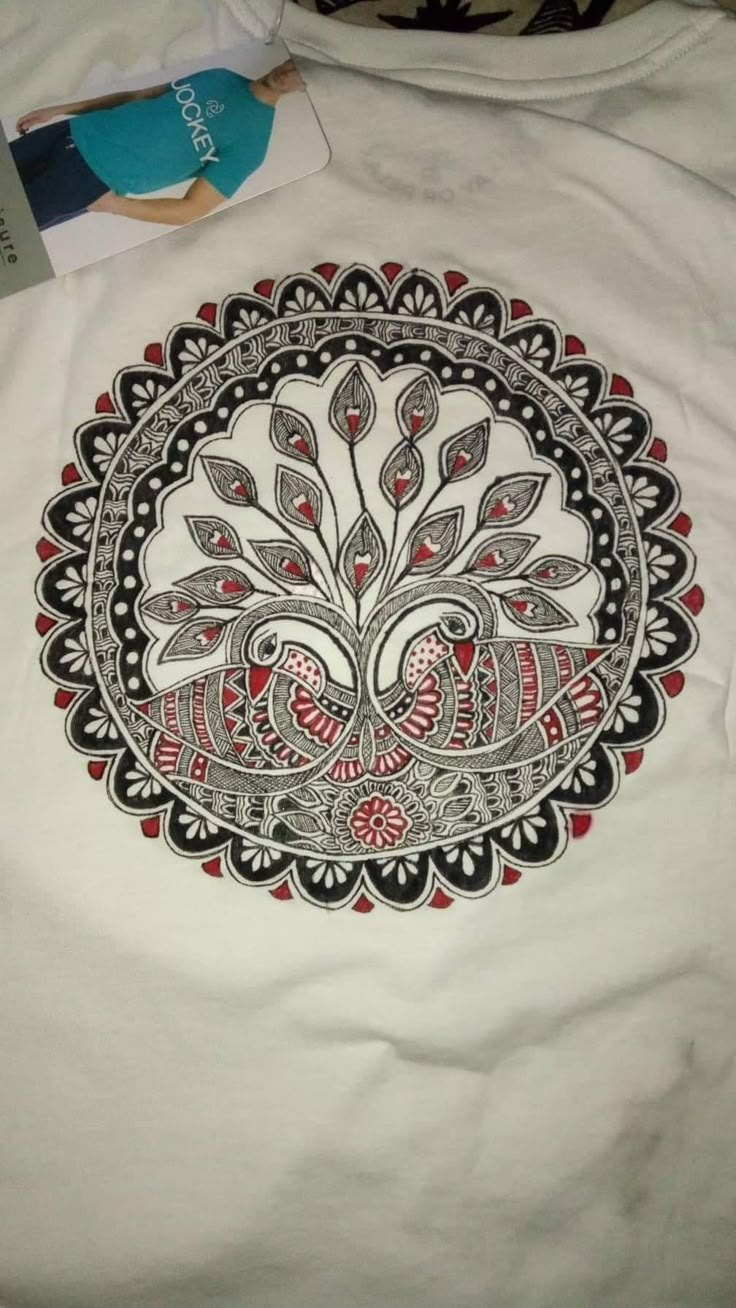 a white t - shirt with red and black designs on it