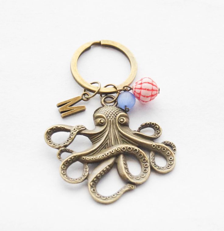 an octopus keychain with two balls attached to it's back and on the front