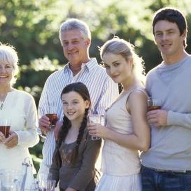 a group of people standing next to each other in front of a table with food and drinks