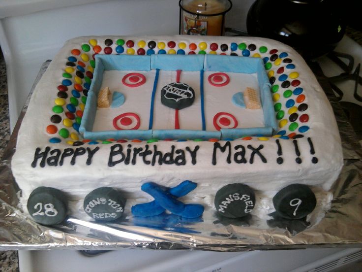 a birthday cake that is decorated with an ice hockey rink and goalies on it