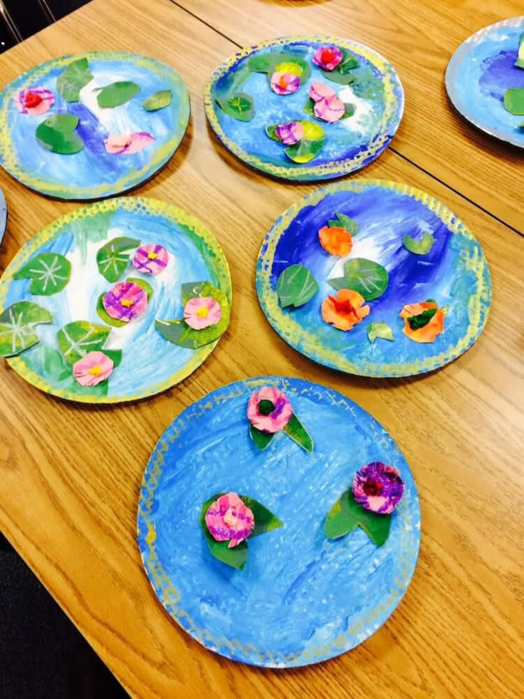 paper plates with flowers painted on them sitting on a table