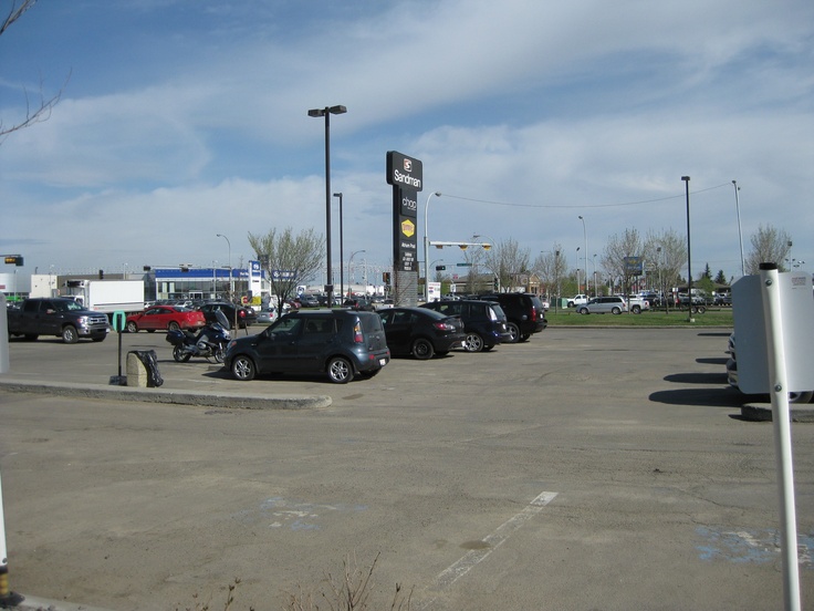 several cars parked in a parking lot next to gas pumps