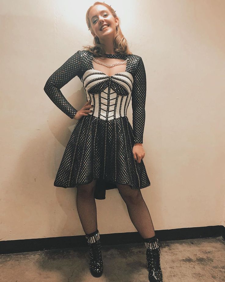 a woman is posing for the camera wearing a corset and tights with her hands on her hips