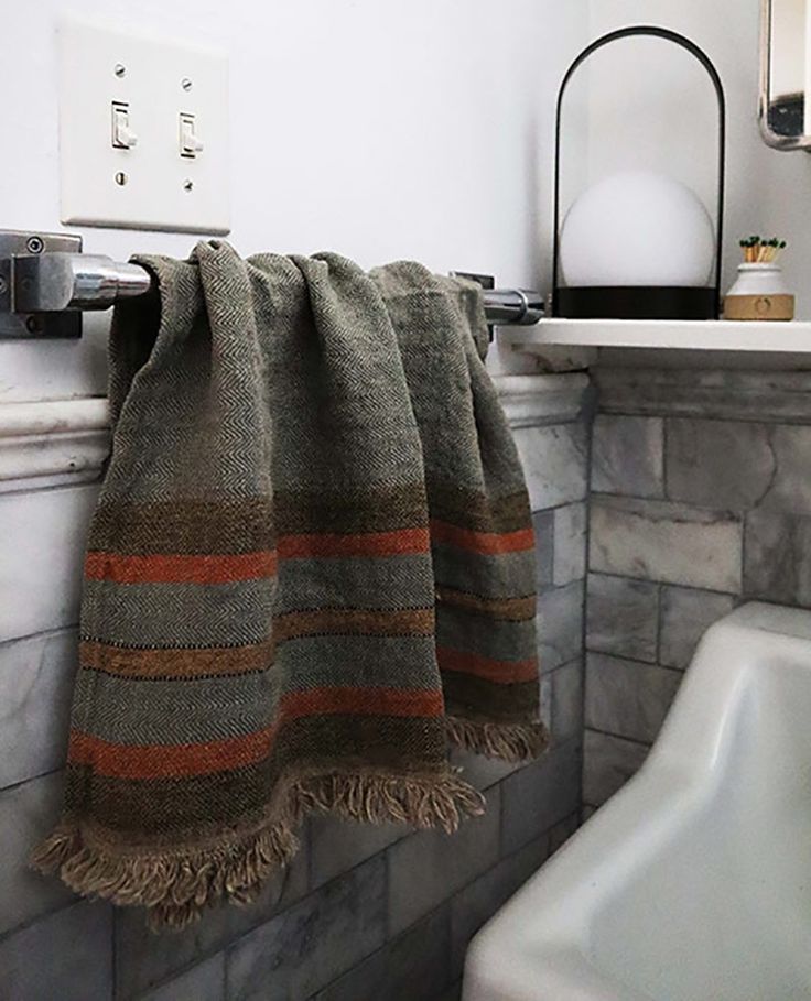 a towel is hanging on the wall next to a sink and faucet in a bathroom