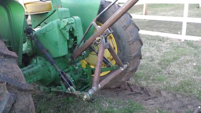 an old green tractor parked in the grass