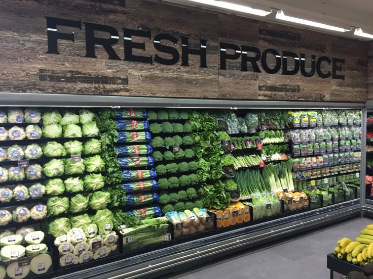 a produce section in a grocery store with fresh produce on the shelves and vegetables displayed