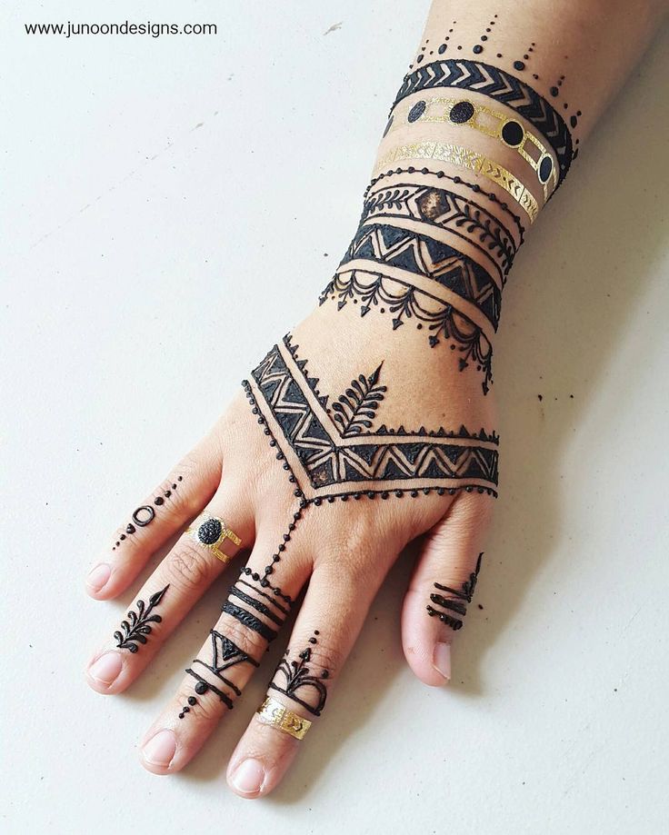 a woman's hand with henna tattoos on it