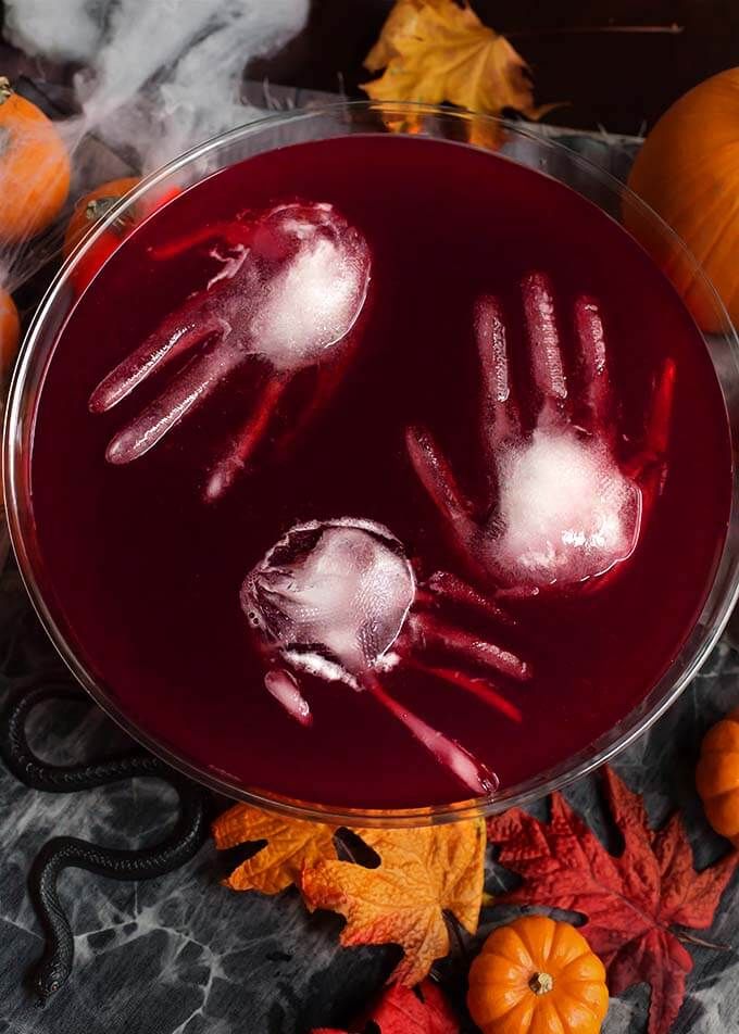 a glass bowl filled with liquid and two handprints on top of it, surrounded by fall leaves