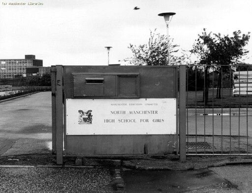 a black and white photo of a fenced in area with a sign on it